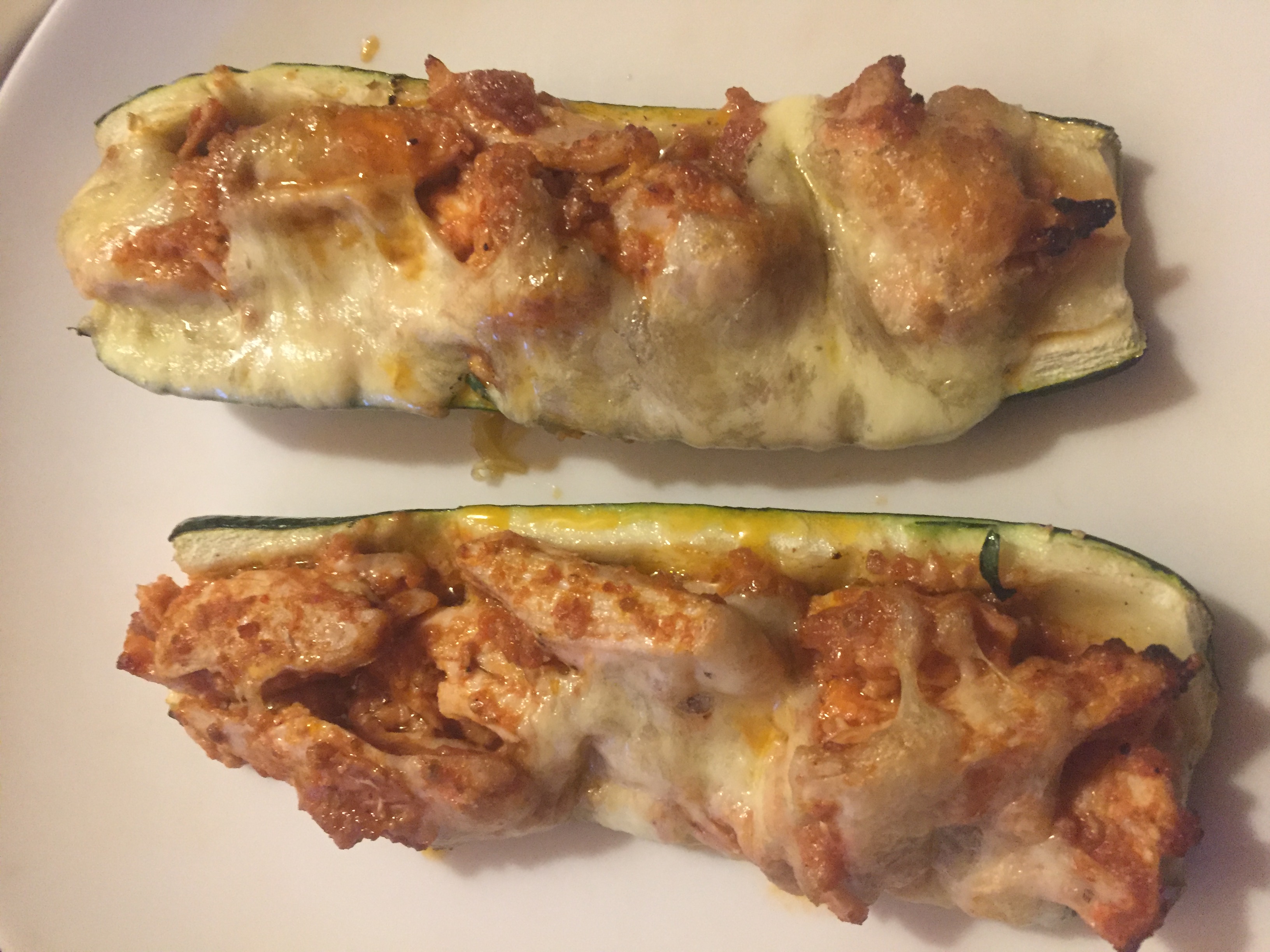 Low carb zucchini boats with red pesto and mozzarella topping